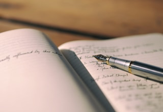 Hands writing in a leather journal